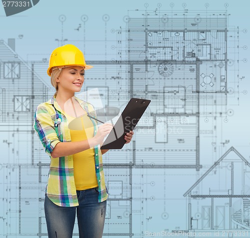 Image of smiling woman in helmet with clipboard