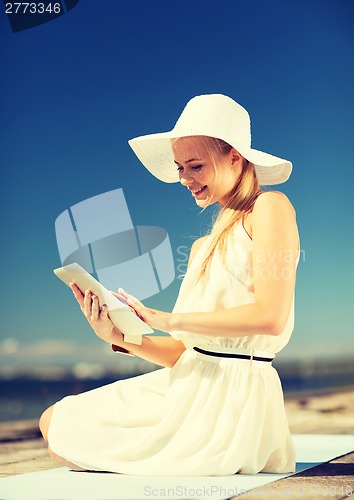 Image of beautiful woman in a dress with tablet pc