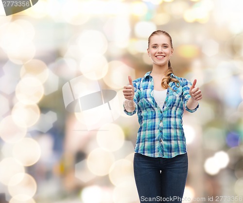 Image of young woman in casual clothes showing thumbs up