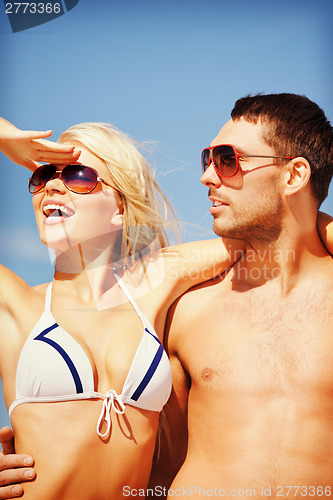 Image of happy couple in sunglasses on the beach