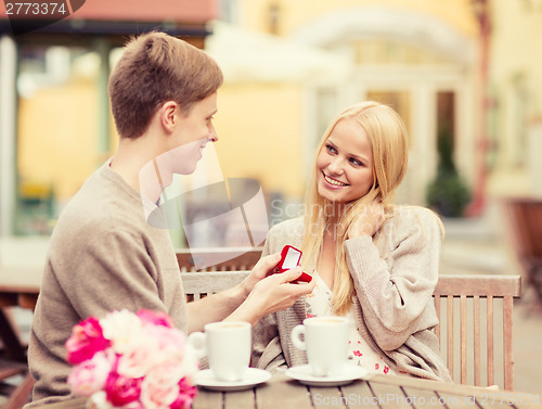 Image of romantic man proposing to beautiful woman