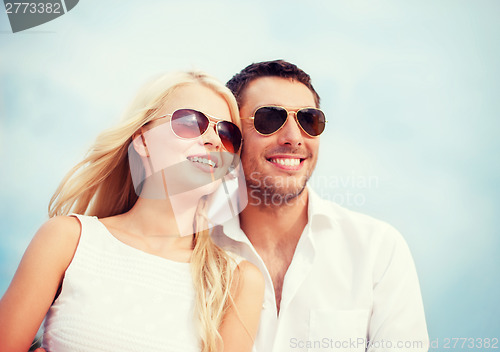 Image of couple in shades at sea side