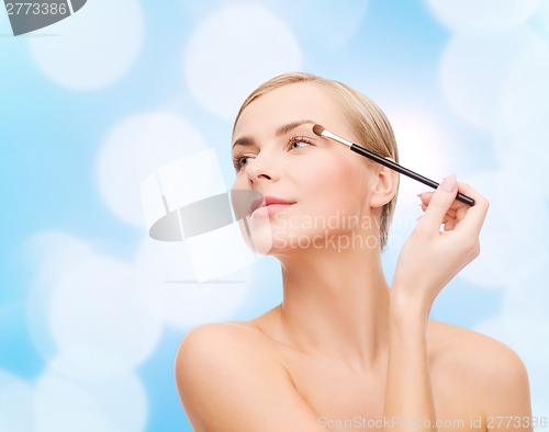 Image of beautiful woman with makeup brush