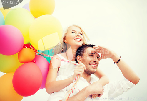 Image of couple with colorful balloons at seaside