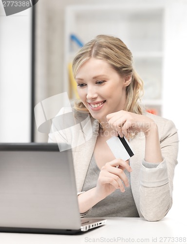 Image of happy woman with laptop computer and credit card