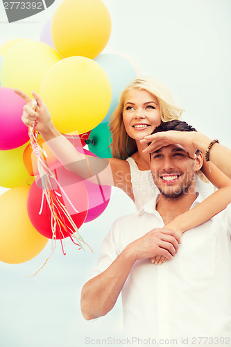 Image of couple with colorful balloons at seaside