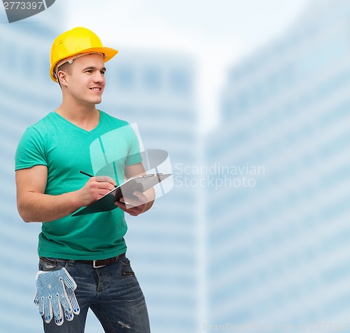 Image of smiling man in helmet with clipboard
