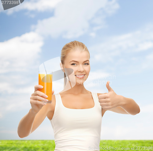 Image of smiling woman holding glass of orange juice