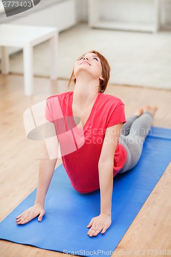 Image of smiling teenage girl streching at home