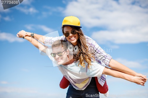 Image of smiling teenagers in sunglasses having fun outside