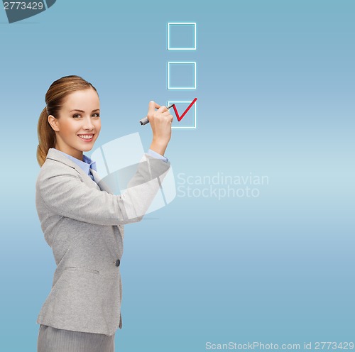 Image of businesswoman writing something in air with marker