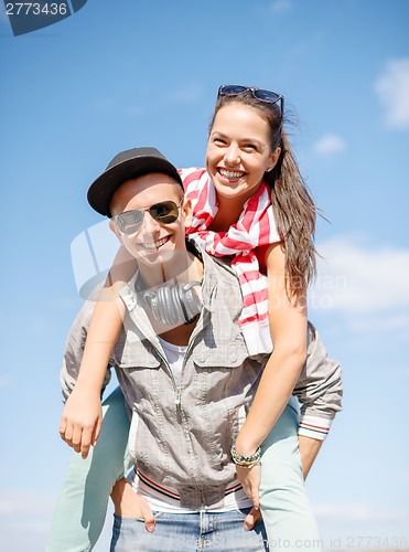 Image of smiling teenagers in sunglasses having fun outside