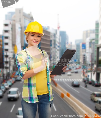 Image of smiling woman in helmet with clipboard