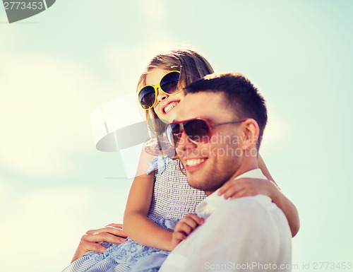 Image of happy father and child in sunglasses over blue sky