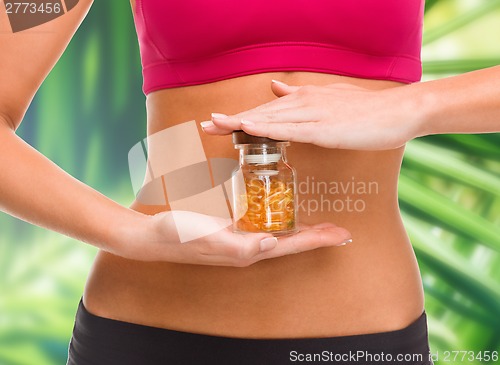 Image of close up of female hands with bottle of capsules