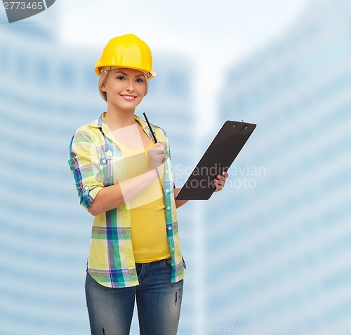 Image of smiling woman in helmet with clipboard