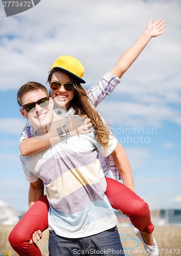 Image of smiling teenagers in sunglasses having fun outside
