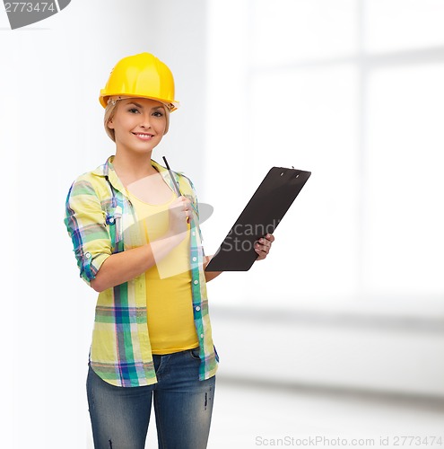 Image of smiling woman in helmet with clipboard