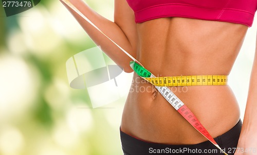 Image of close up of trained belly with measuring tape