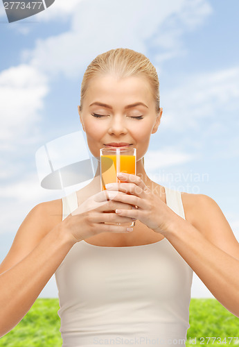 Image of young woman drinking orange juice