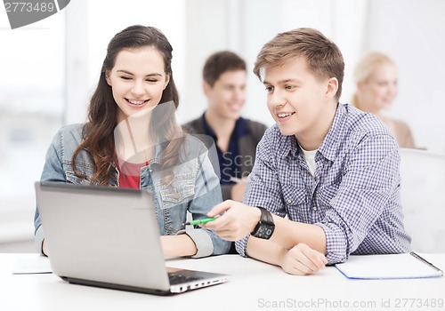 Image of students with laptop and notebooks at school