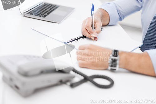 Image of businessman writing in notebook