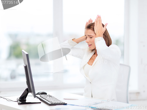 Image of stressed businesswoman with computer at work