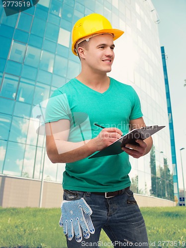 Image of smiling man in helmet with clipboard