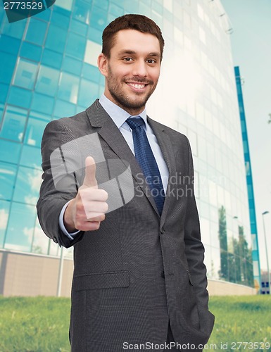 Image of handsome businessman showing thumbs up