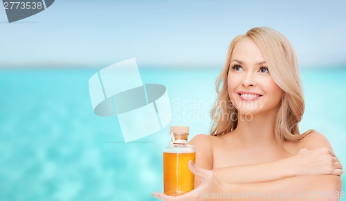 Image of happy woman with oil bottle