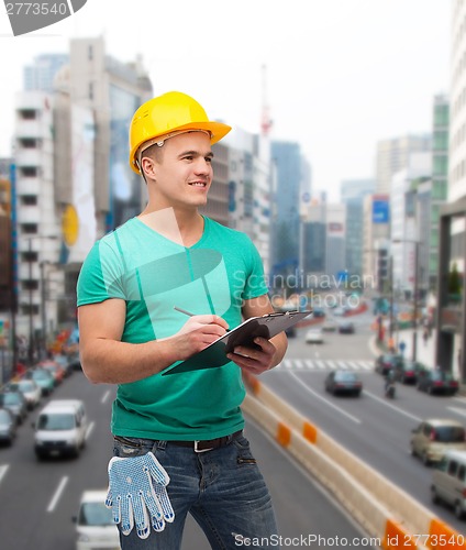 Image of smiling man in helmet with clipboard