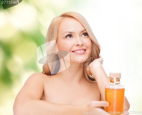 Image of happy woman with oil bottle
