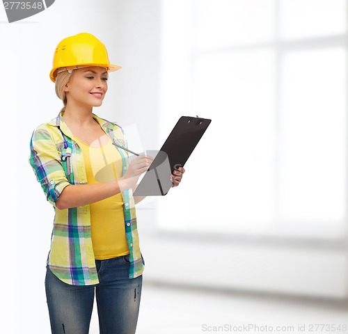 Image of smiling woman in helmet with clipboard