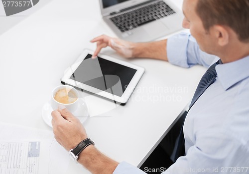 Image of businessman with tablet pc and coffee in office