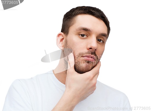 Image of beautiful calm man touching his face