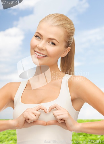 Image of smiling woman showing heart shape gesture