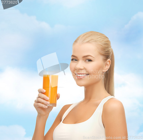 Image of smiling woman holding glass of orange juice