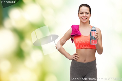 Image of sporty woman with towel and water bottle