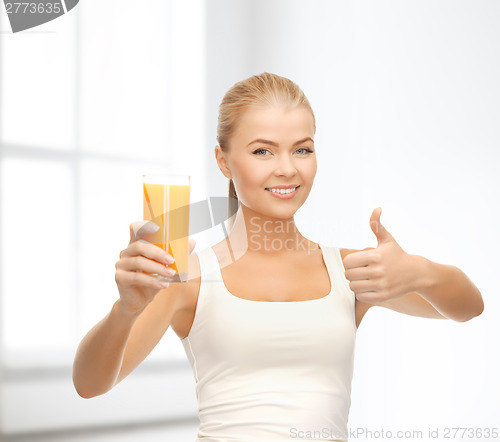 Image of smiling woman holding glass of orange juice