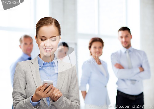 Image of young smiling businesswoman with smartphone