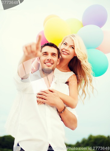 Image of couple with colorful balloons at sea side