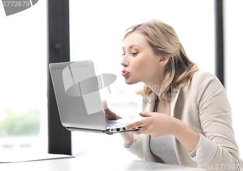 Image of woman with computer kissing the screen