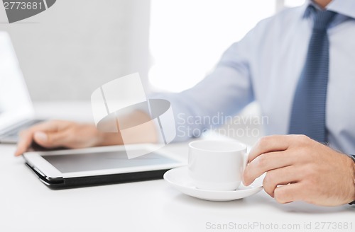 Image of businessman with tablet pc and coffee in office