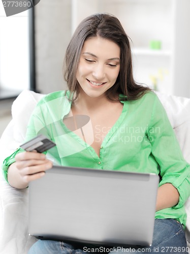 Image of happy woman with laptop computer and credit card