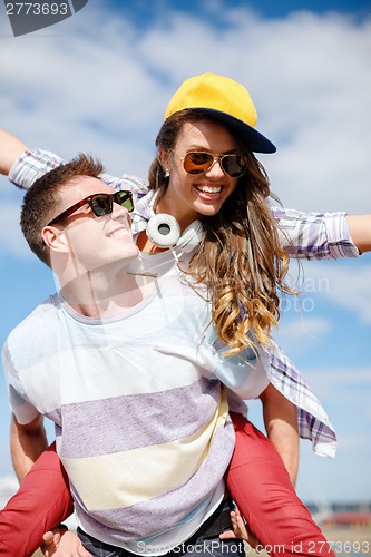 Image of smiling teenagers in sunglasses having fun outside