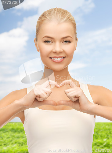 Image of smiling woman showing heart shape gesture