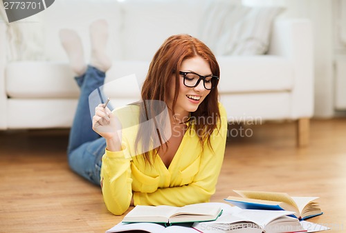 Image of smiling student girl reading books at home