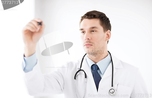 Image of young doctor working with something imaginary