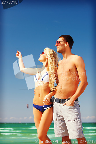 Image of happy couple in sunglasses on the beach