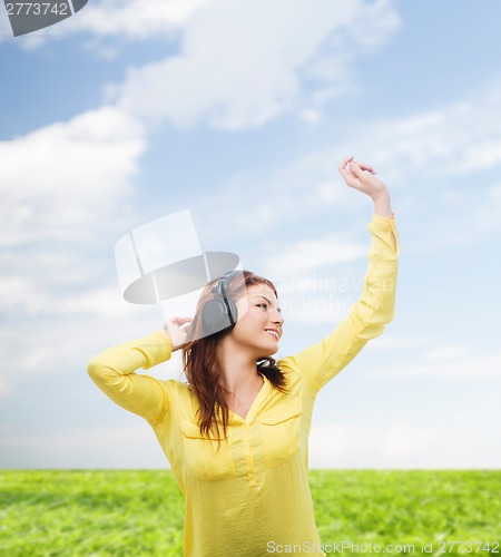 Image of teenage girl sitting on sofa with headphones